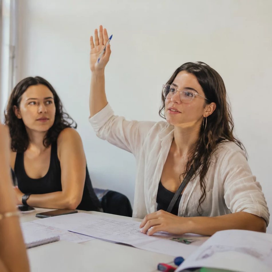 Roda de participantes; um deles repete em voz alta o argumento do colega antes de dar a resposta